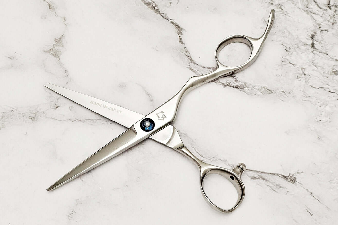 Pair of hair scissors on marble surface
