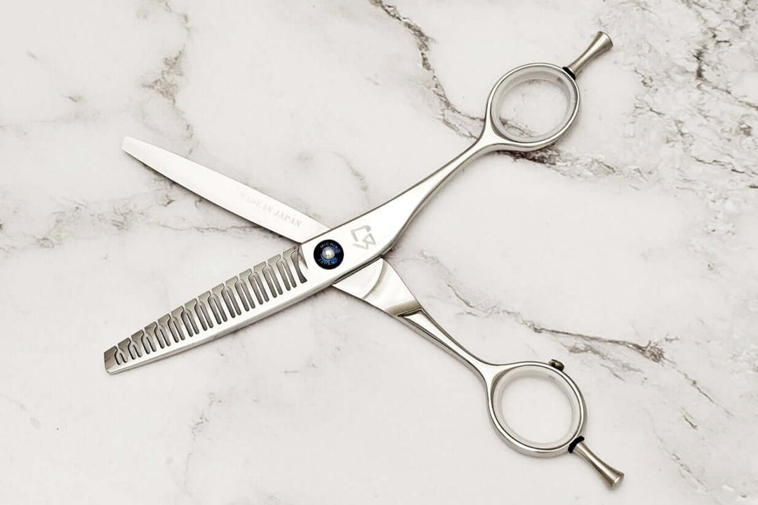 Hair texturizing shears on a marble surface
