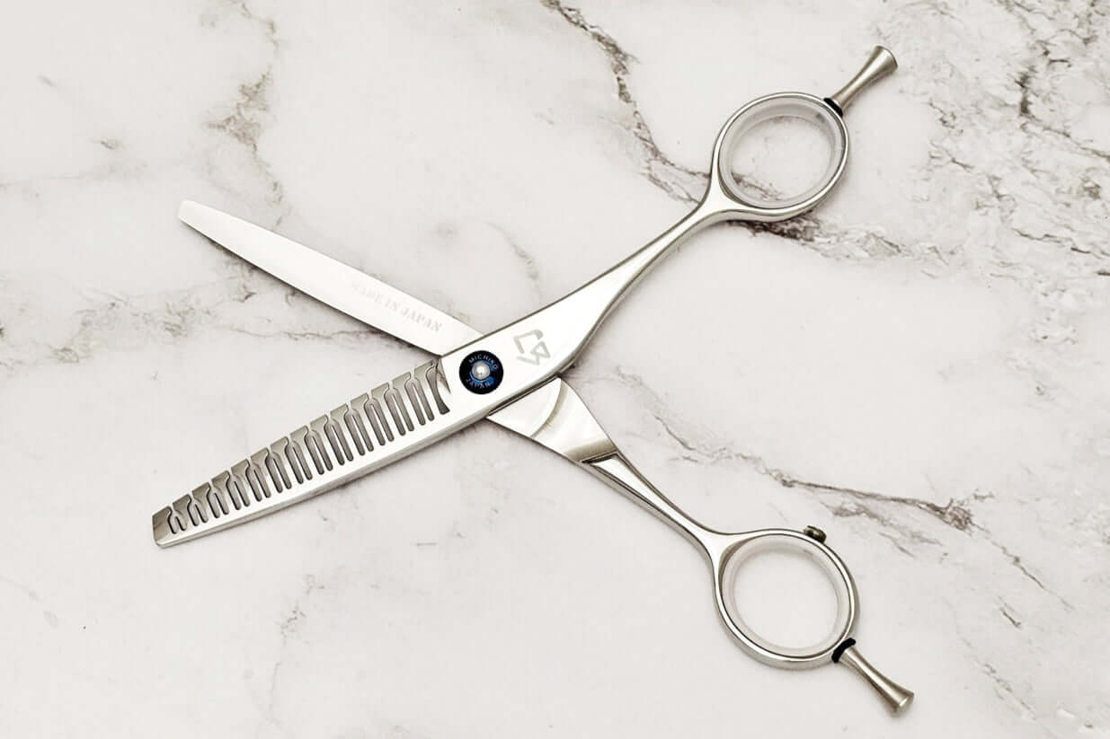 Hair texturizing shears on a marble surface