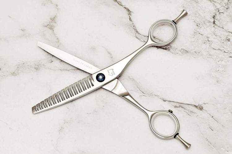 Hair texturizing shears on a marble surface