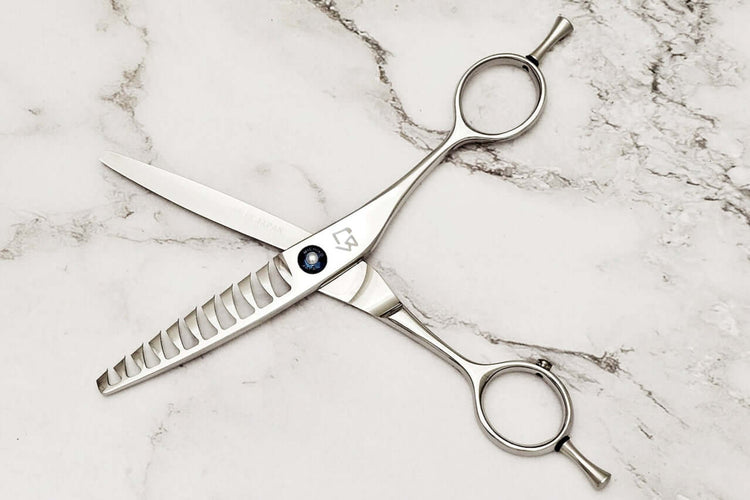 Reversible hair texturizing scissors on a marble surface