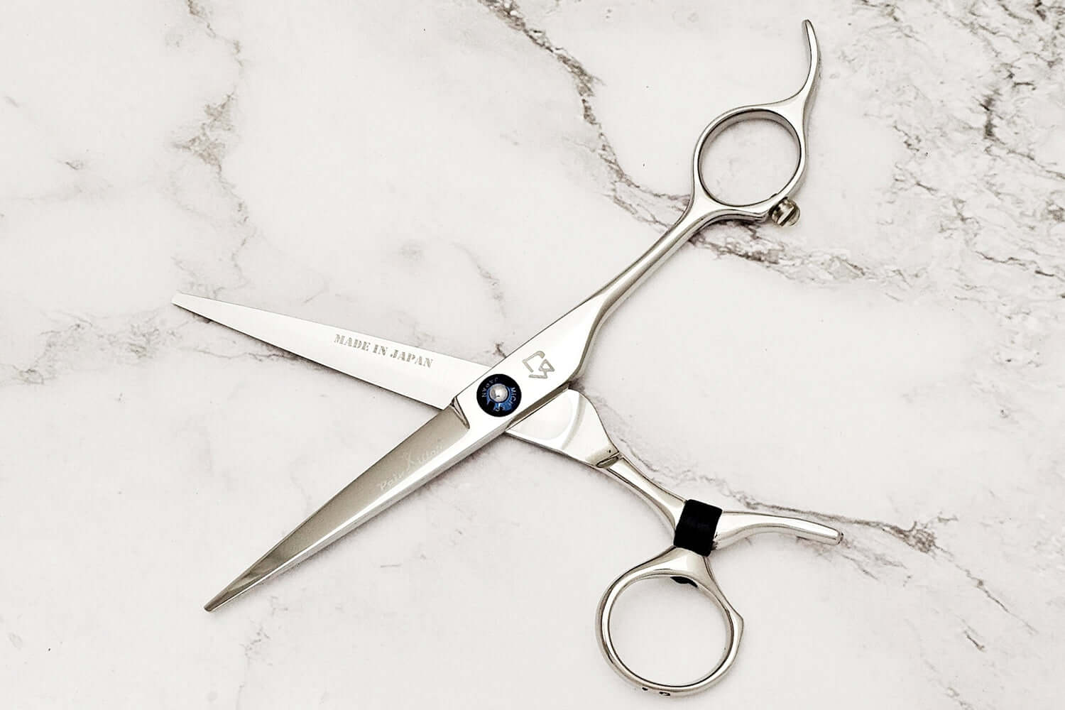 Swivel hair scissors on a marble surface