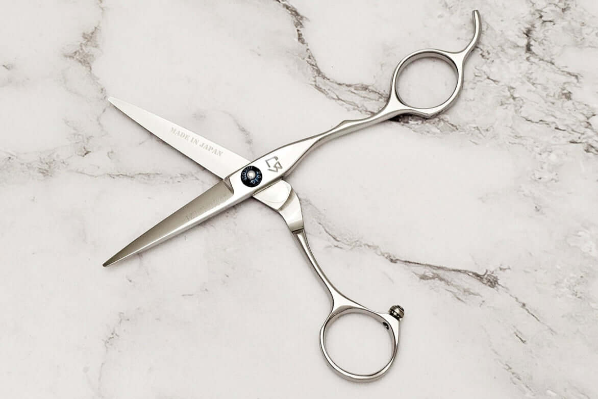 Pair of hair scissors on a marble surface