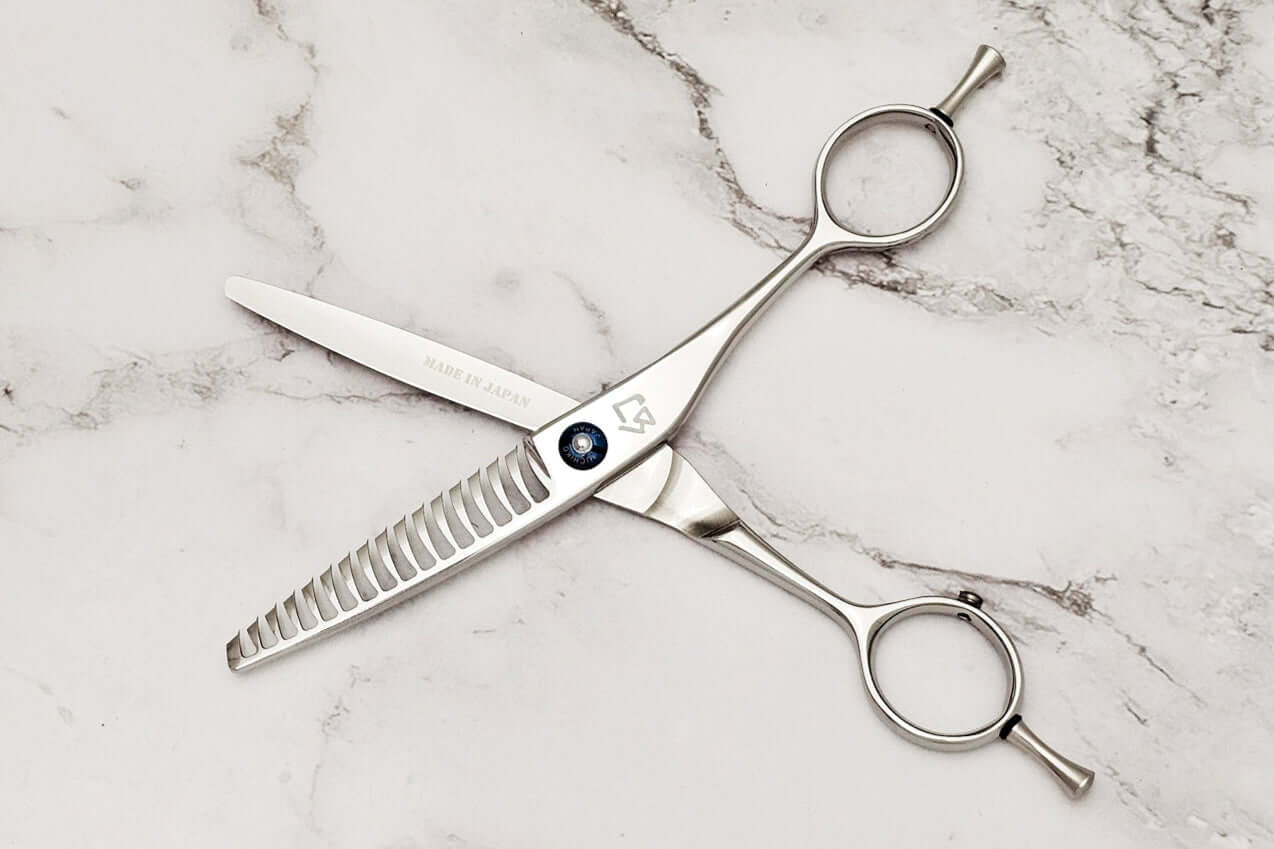 Reversible hair texturizing shears on a marble surface