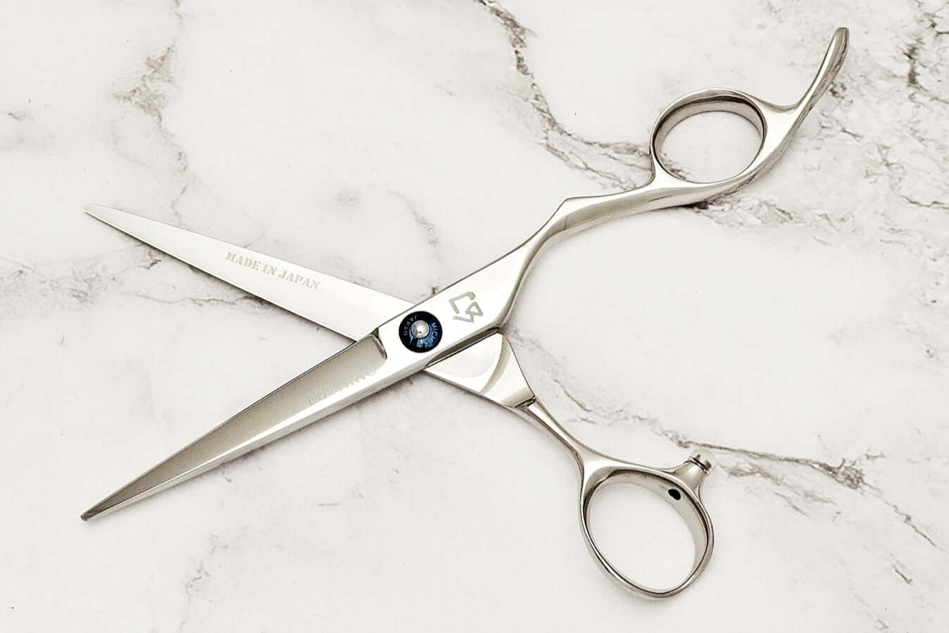 KM 6.0" hair shears on a marble surface 