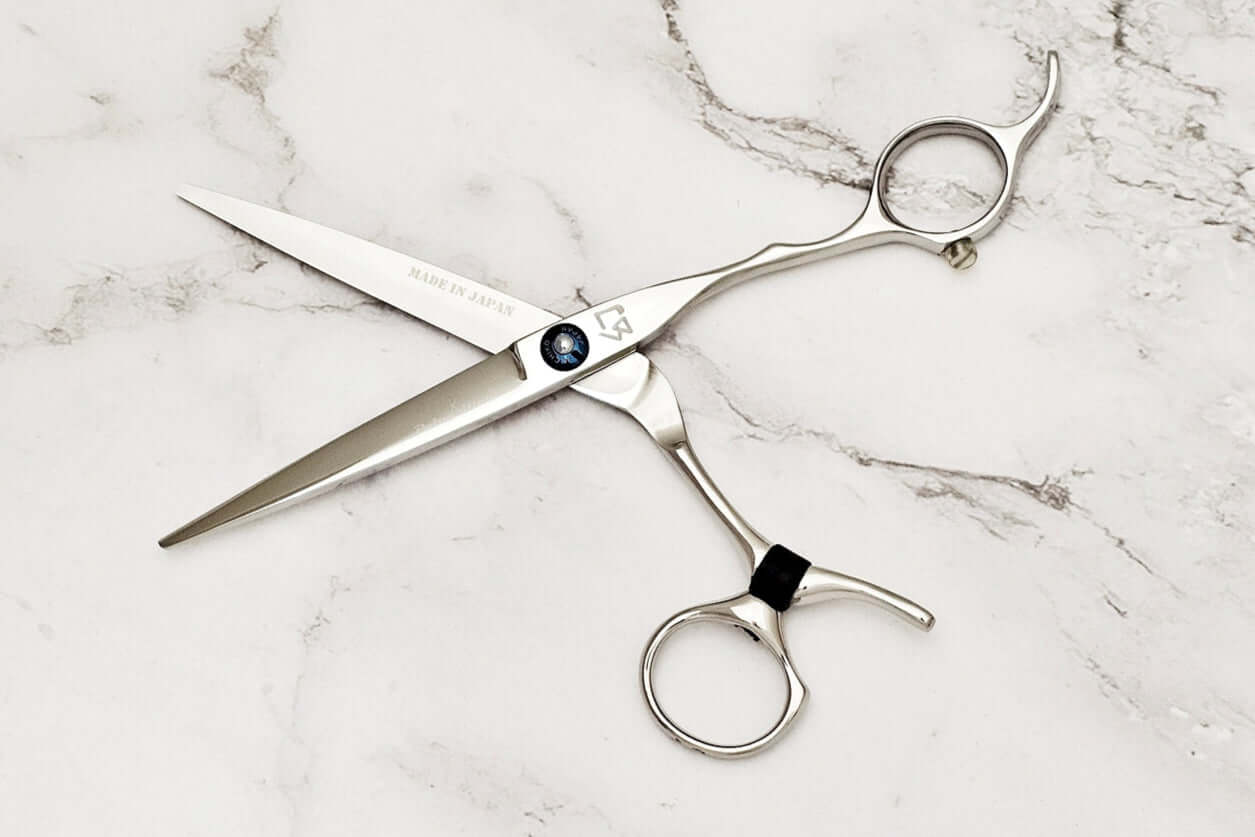 Swivel hair cutting scissors on a marble background