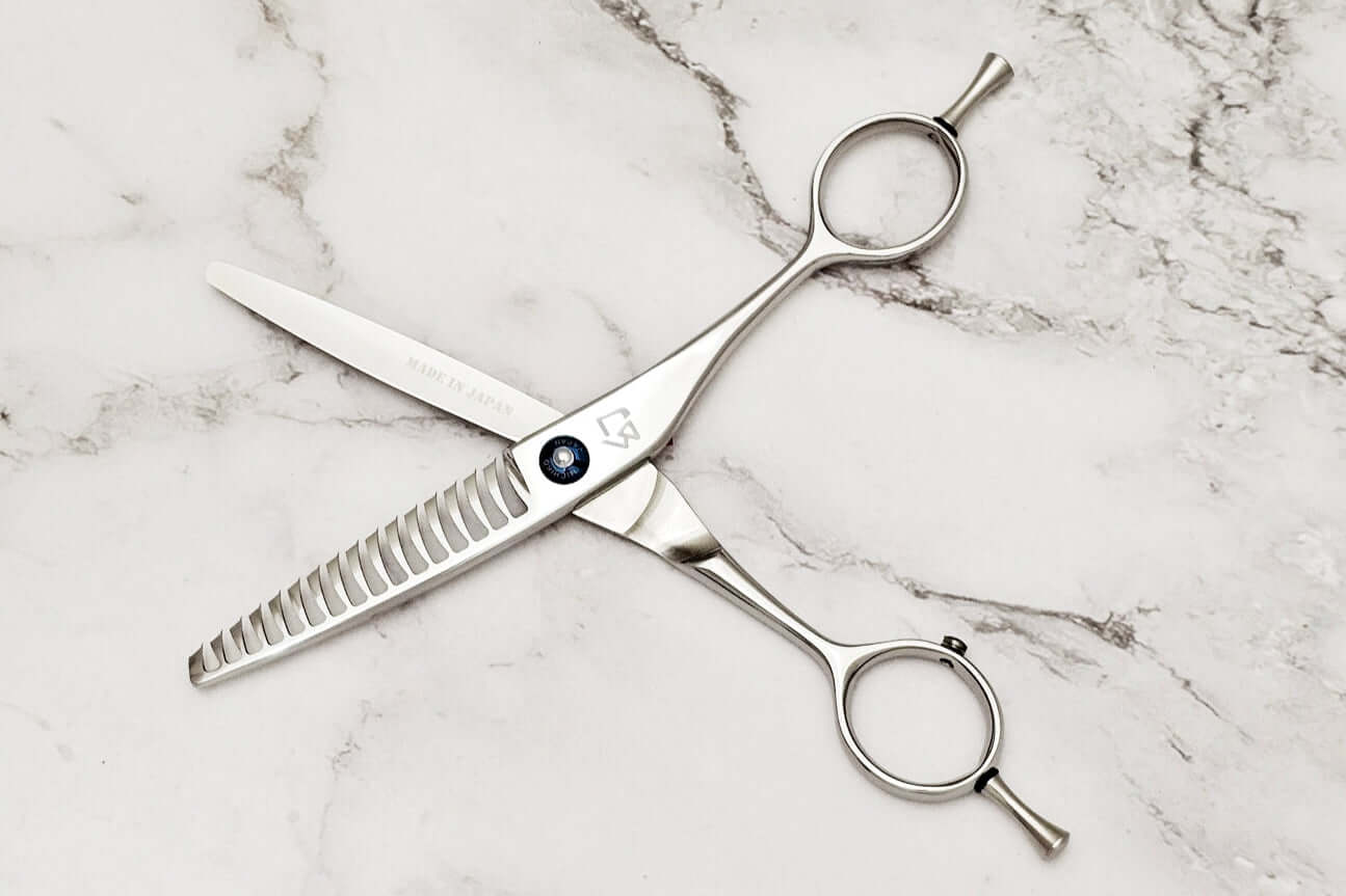 Reversible hair texturizing shears on a marble surface