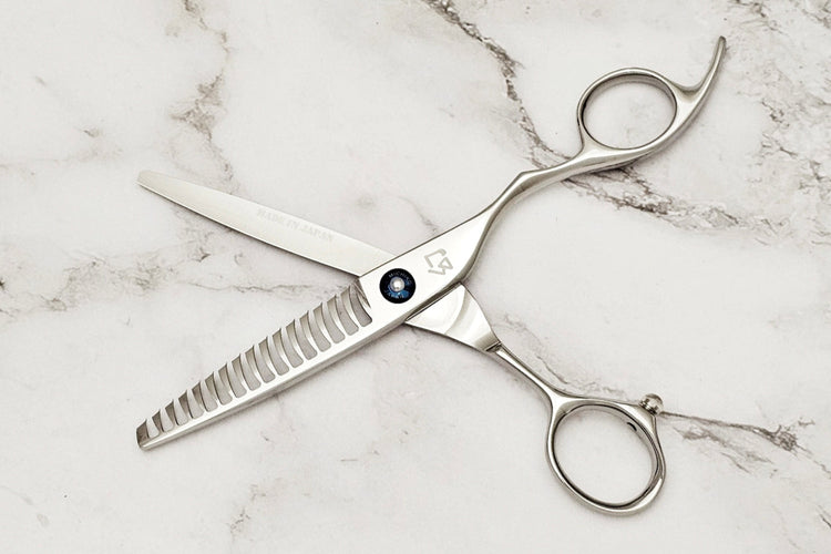 Hair cutting shears on a marble surface
