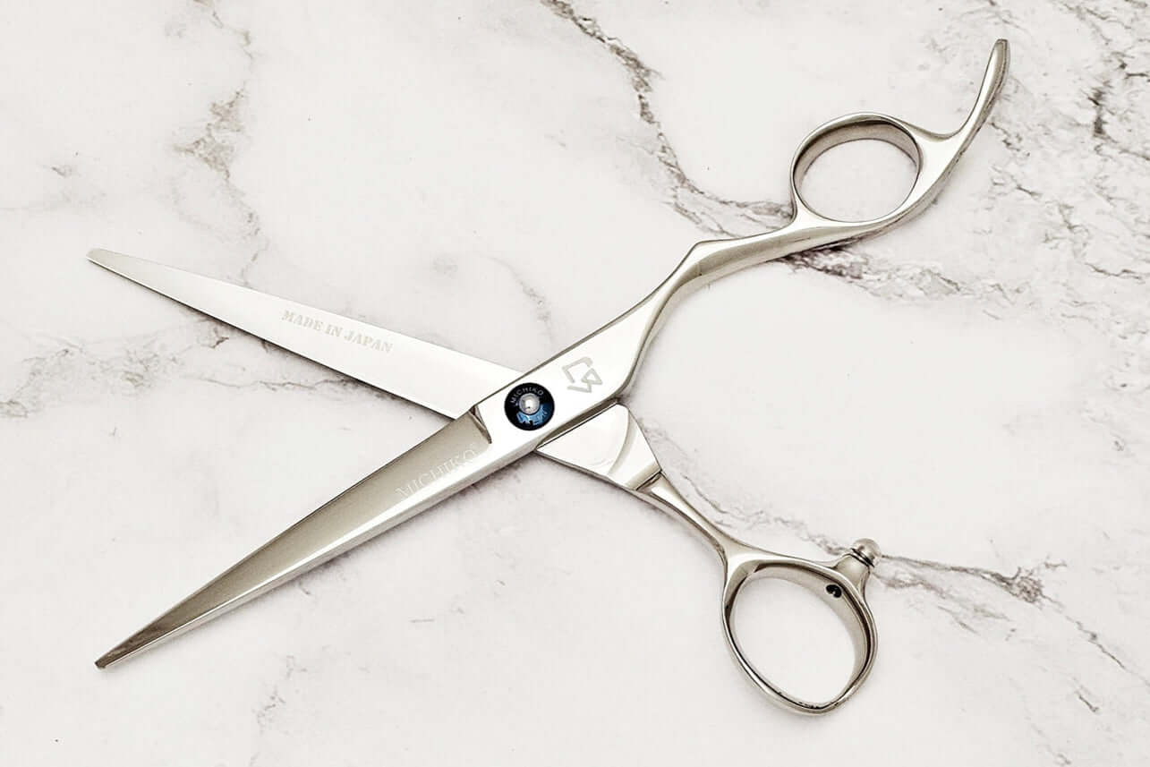 KM 6.5" barber shears on a marble surface.