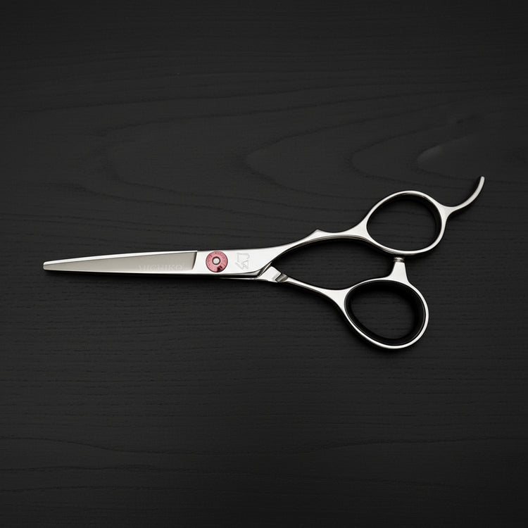 Hair cutting scissors on a dark wooden surface