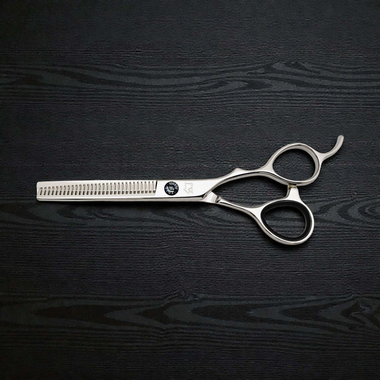 Hair cutting scissors on a black wooden surface