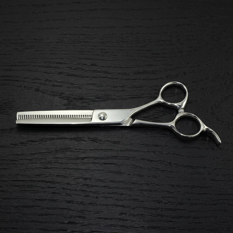 Barber thinning scissors on a black background.