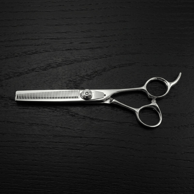 Barber thinning scissors on a black background.