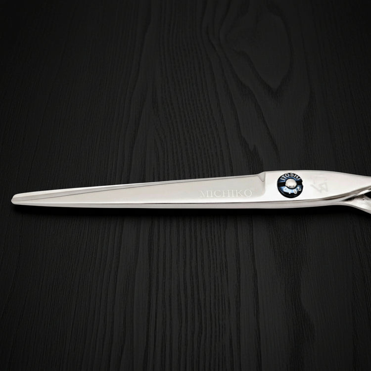 Hair-cutting scissors with a brand logo on a black oak textured background