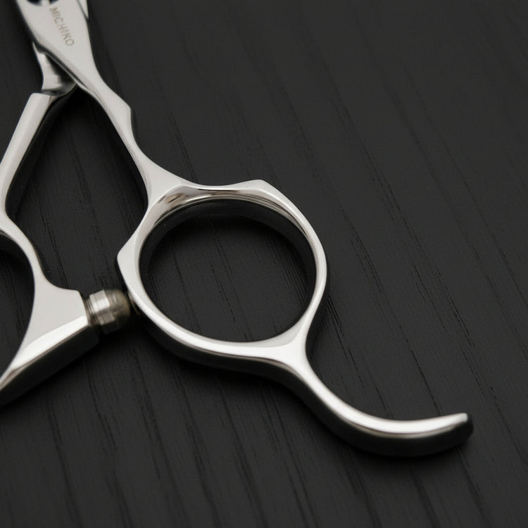 Close-up of a pair of silver scissors on a black oak textured background
