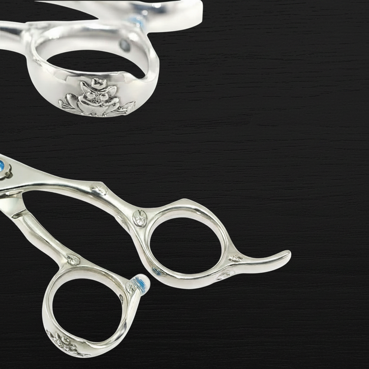 Silver scissors with a brand logo on a black background