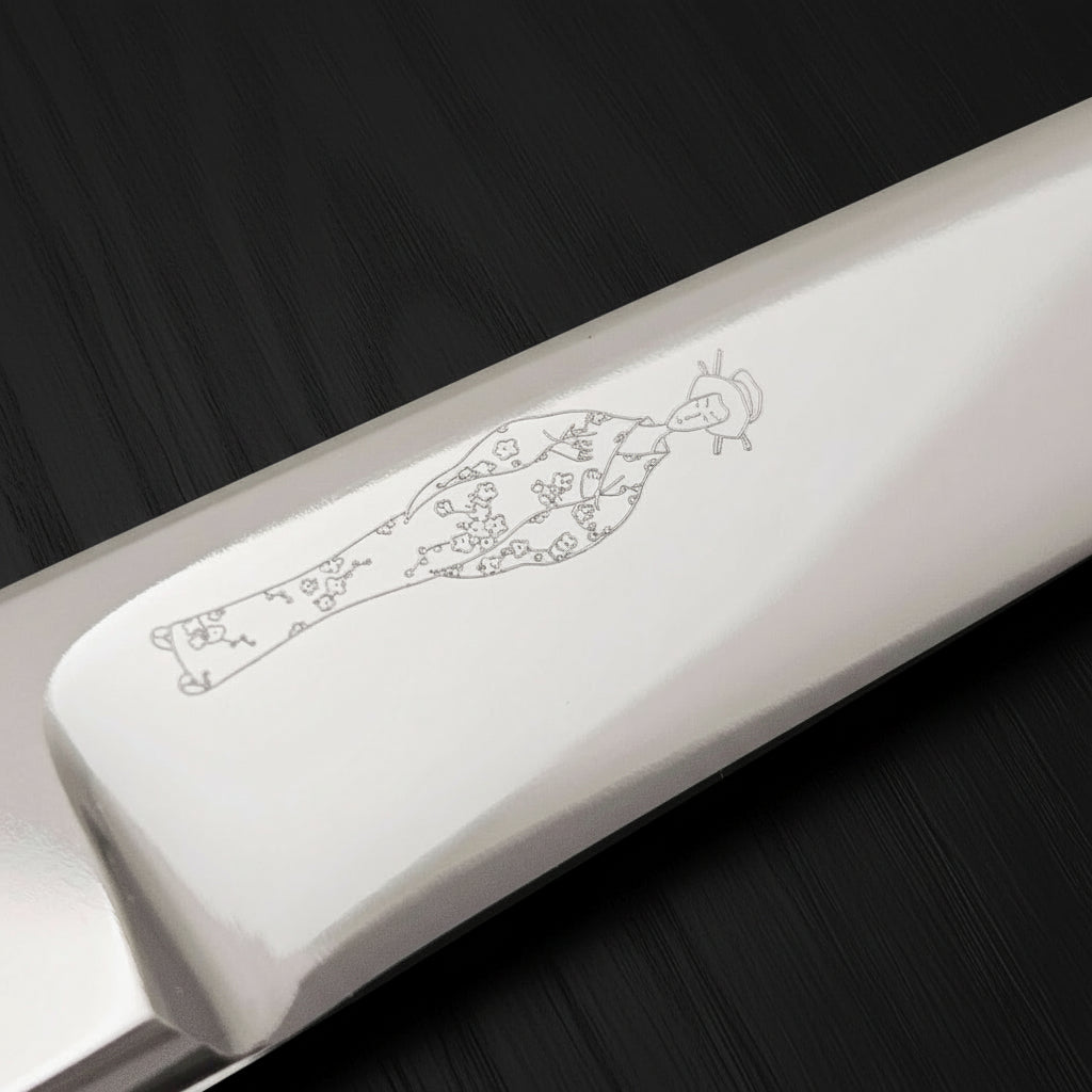 Professional Japanese hair cutting shears close-up showing detailed engraving on the handle.