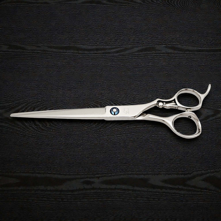 Silver scissors with a brand logo on a black textured background