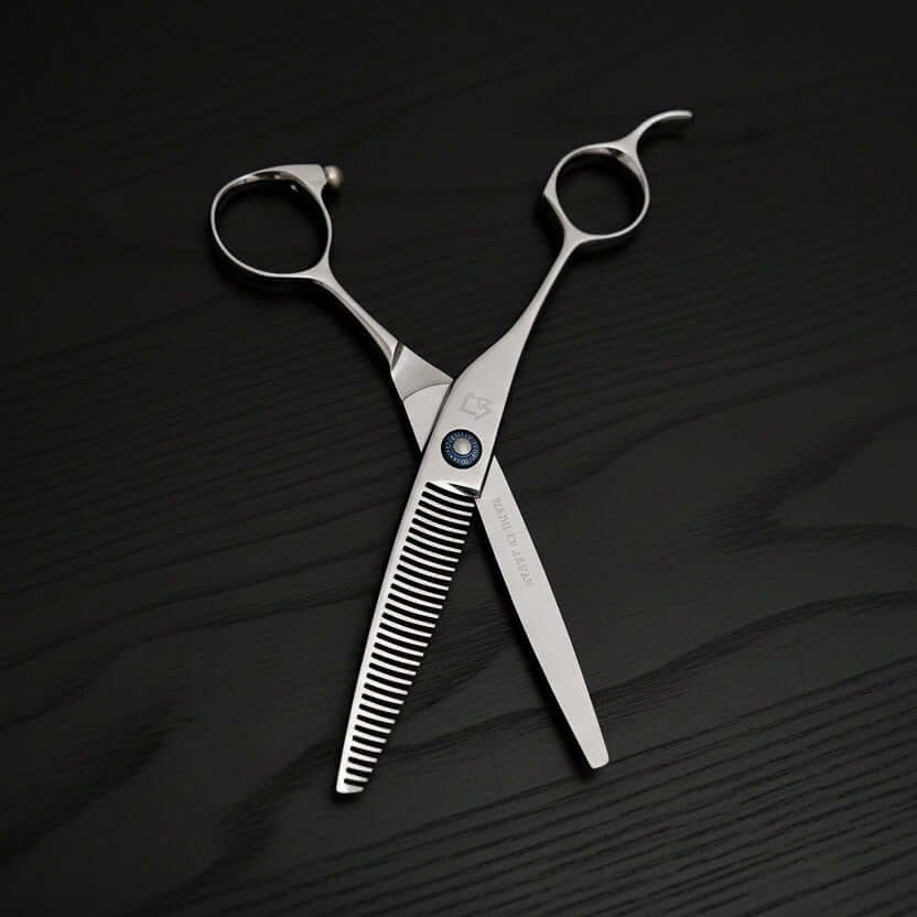 Pair of silver scissors on a textured black surface