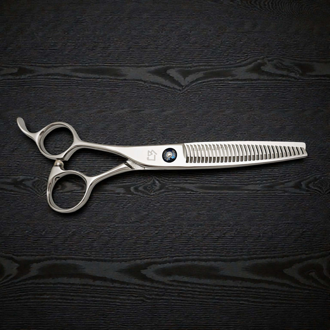 Hairdressing scissors on a black textured surface