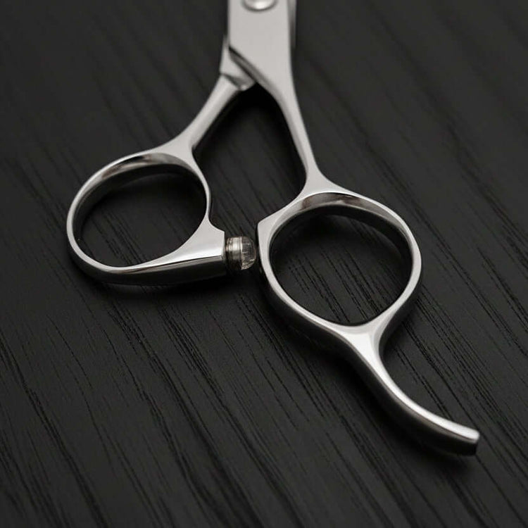 Silver scissors on a light gray background