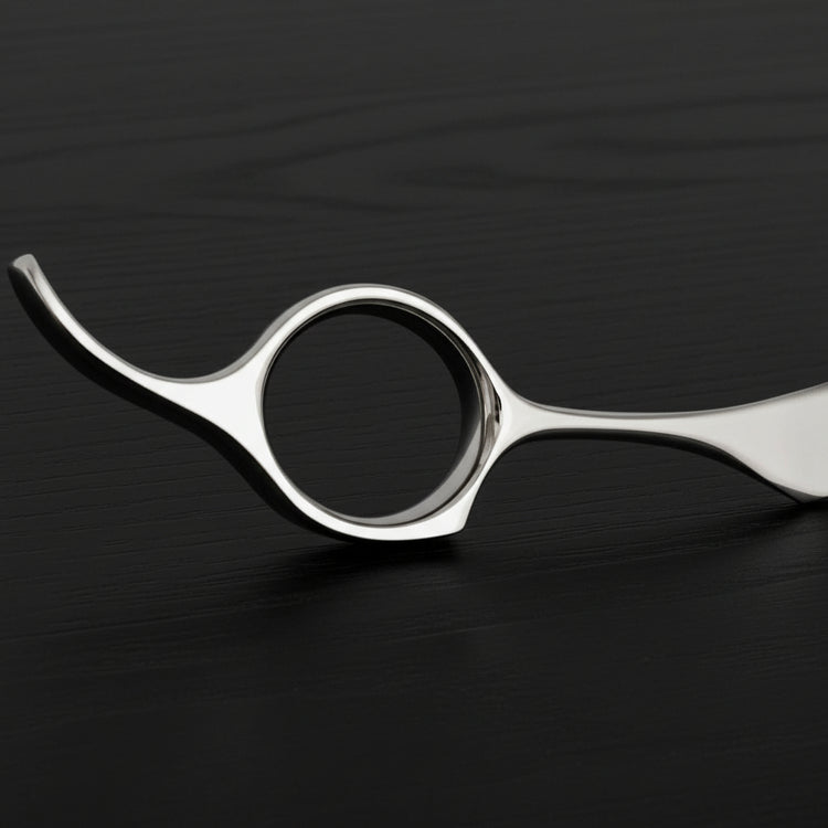 Metallic hairdressing shears on a black oak textured background