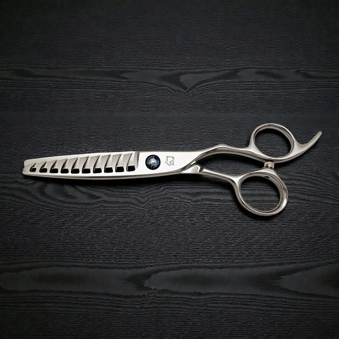 Silver hairdressing scissors on a black textured background