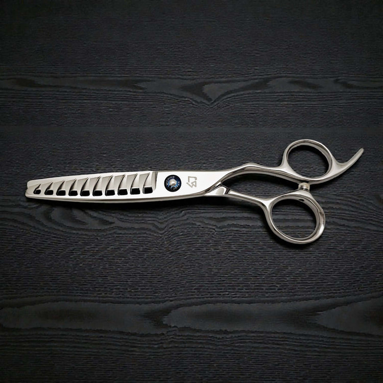 Silver hairdressing scissors on a black textured background