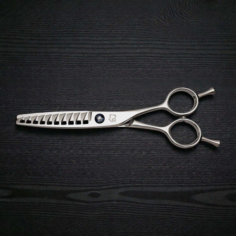 Hair cutting scissors on a black textured surface