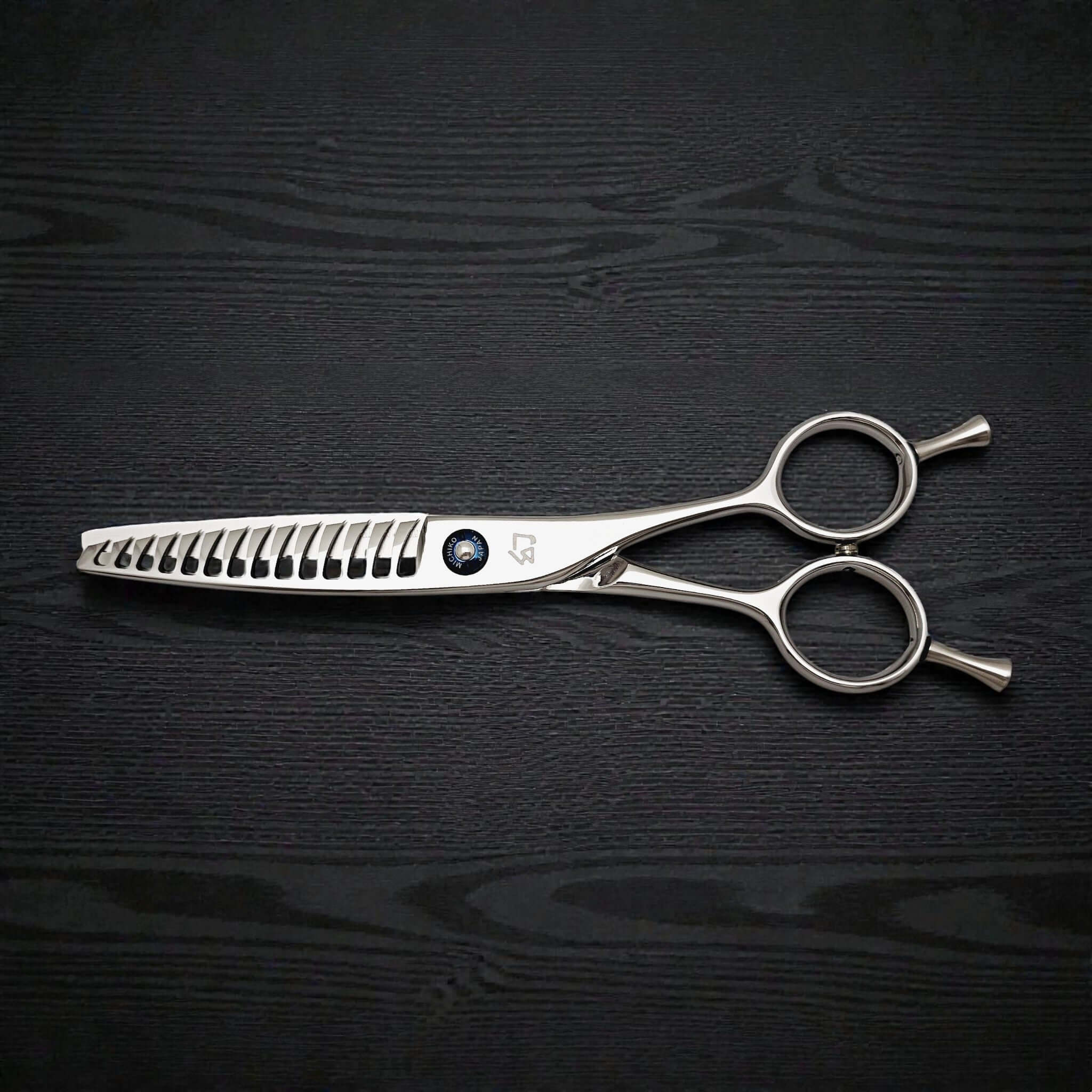 Hair texturizing shears on a black wooden surface