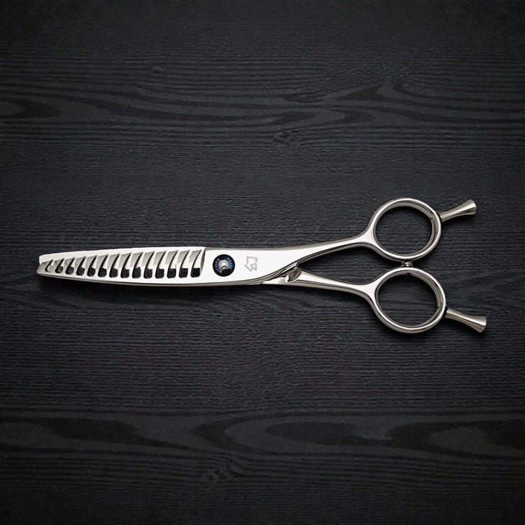 Hair texturizing shears on a black wooden surface