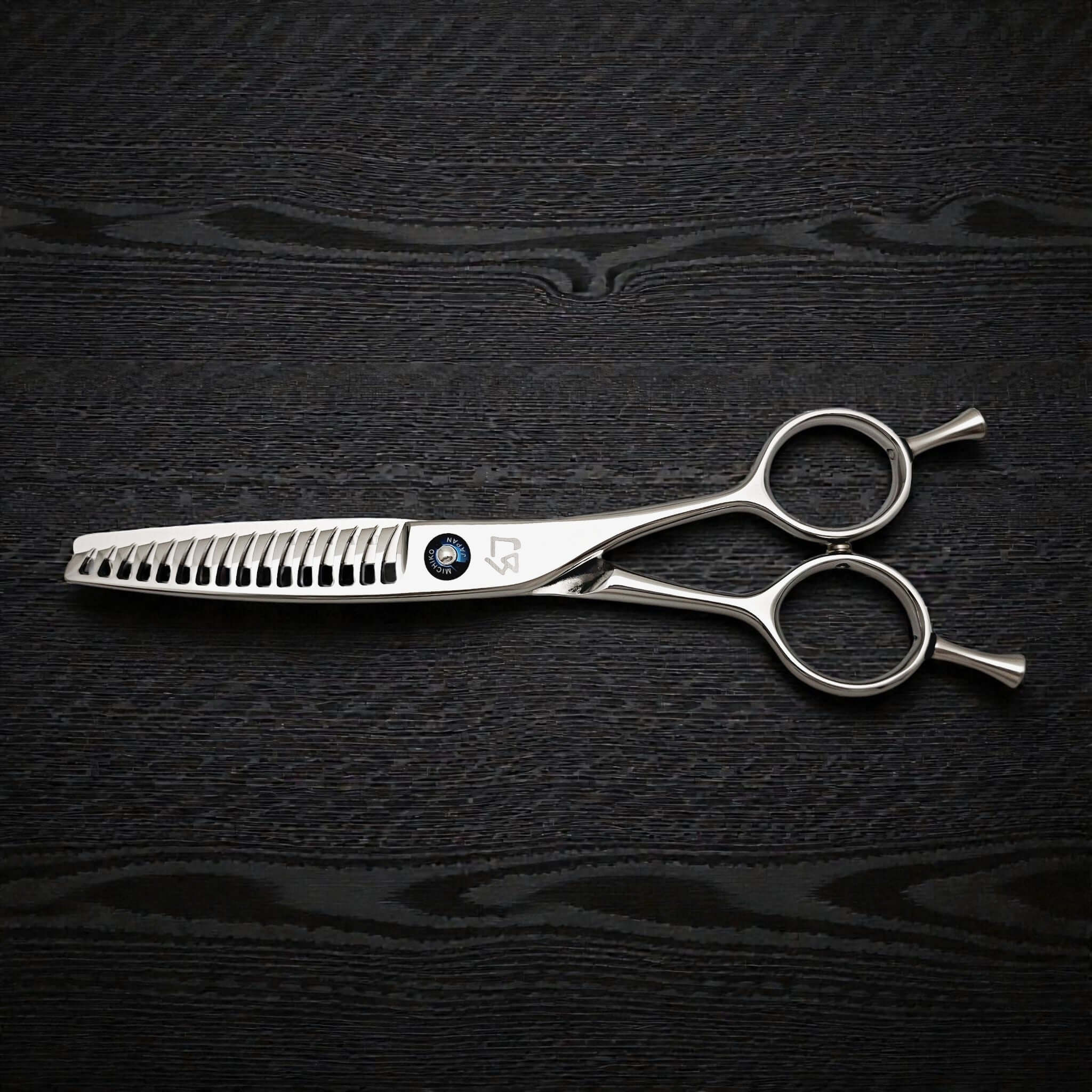Hair cutting shears on a dark textured surface