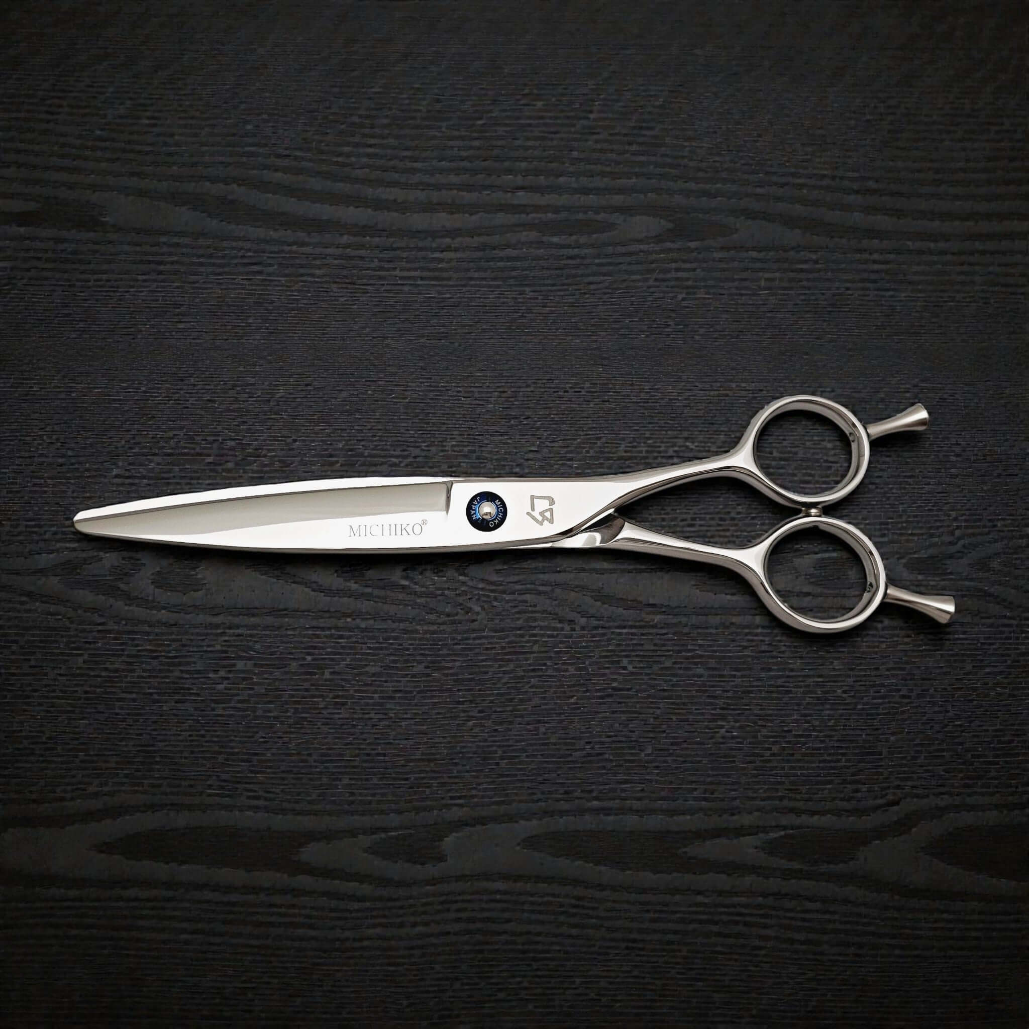 Hair cutting shears on a black textured background