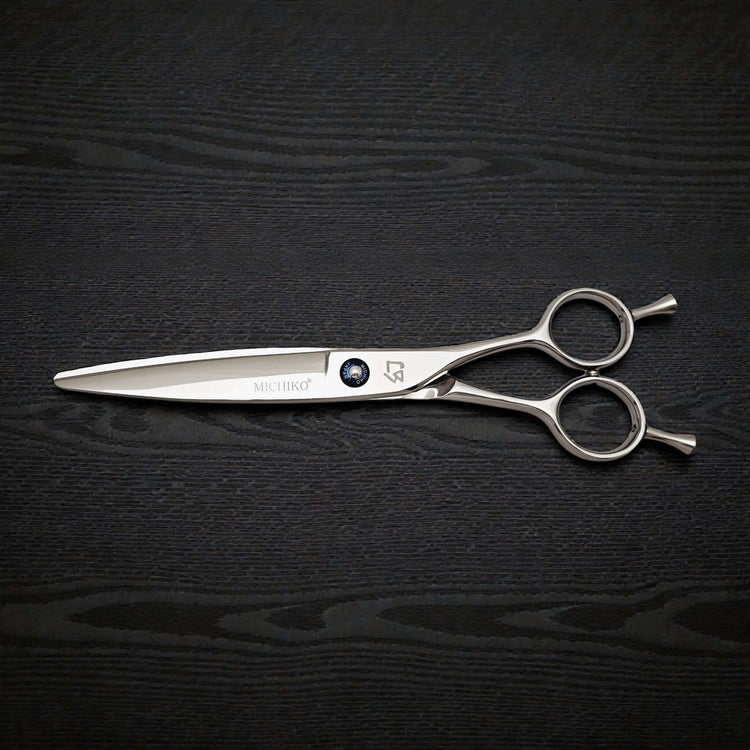 Hair cutting shears on a black textured background
