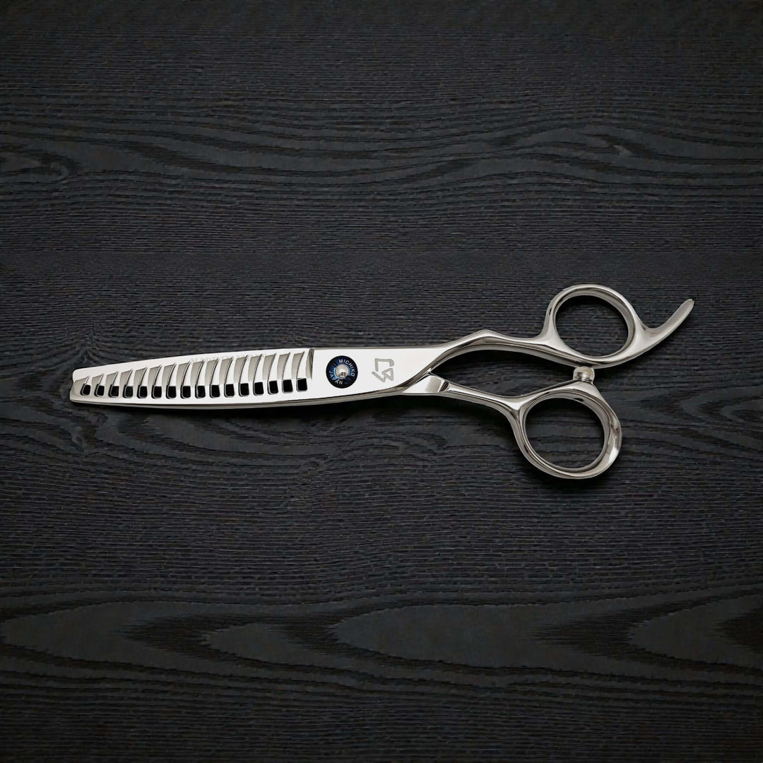 Silver hair cutting scissors on a black wooden surface