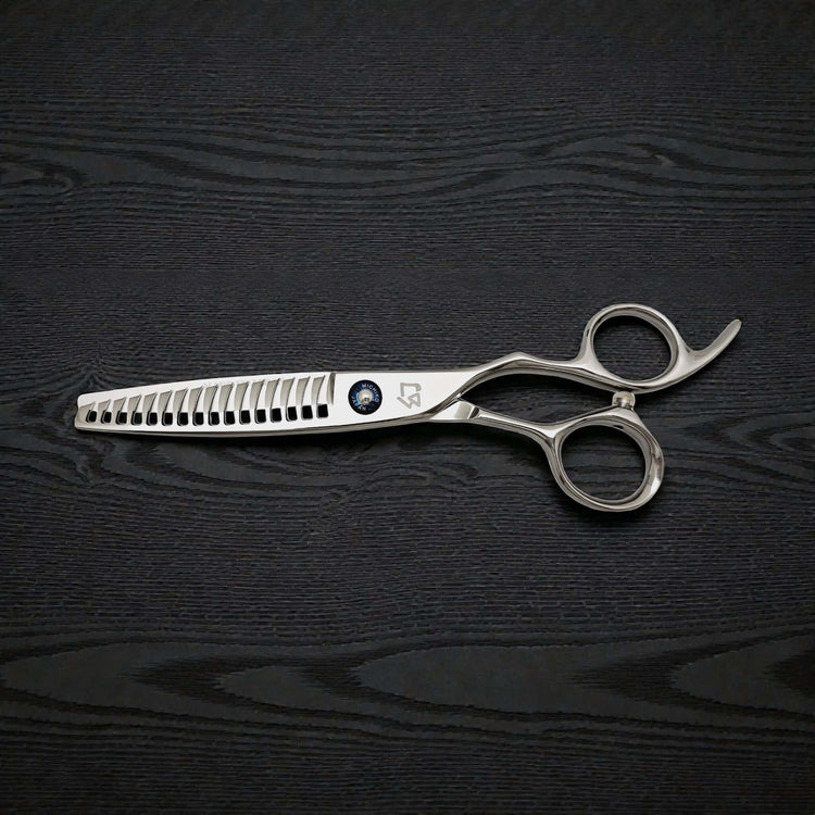 Silver hair cutting scissors on a black wooden surface