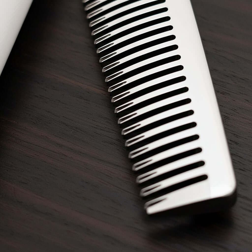 Close-up of hair thinner blade on a dark wooden surface