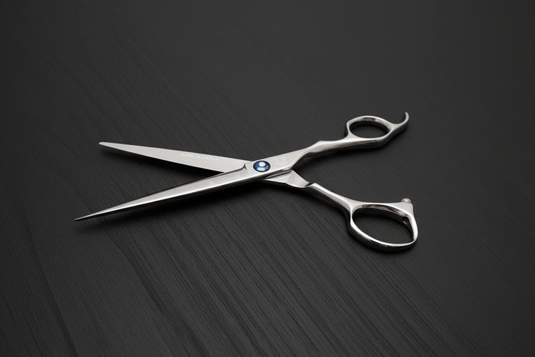 Pair of hair scissors on a dark textured surface