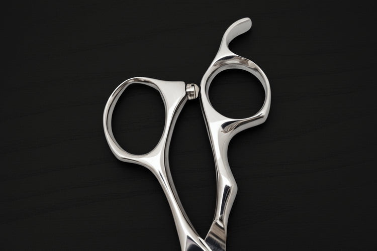 Close-up of hair scissors handle on a black background