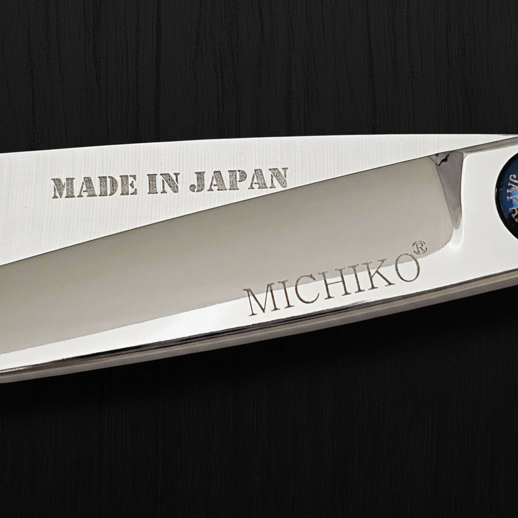 Close-up of a hair scissor blade with 'Made in Japan' and 'Michiko' branding on a black background.