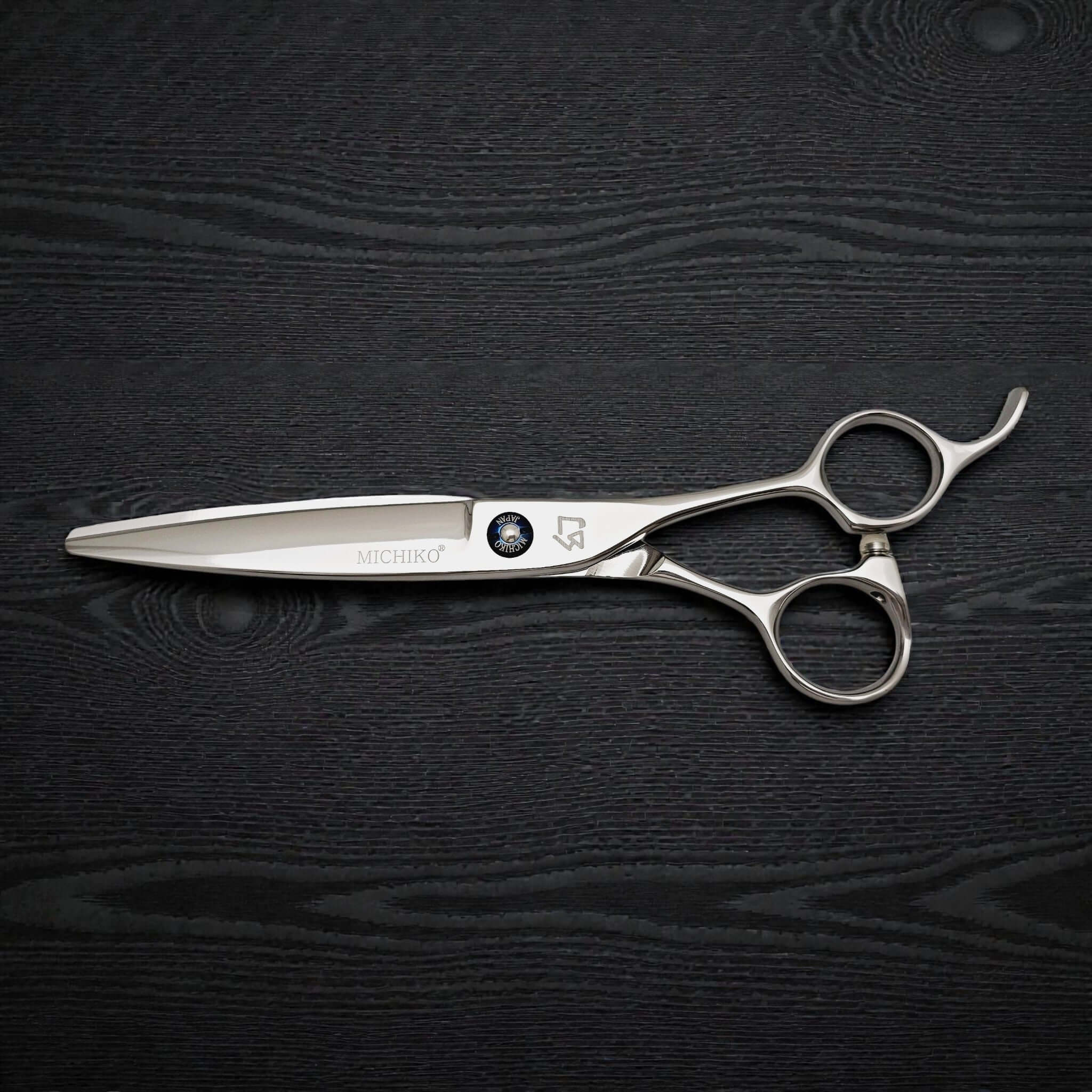 Hair cutting shears on a dark wooden surface