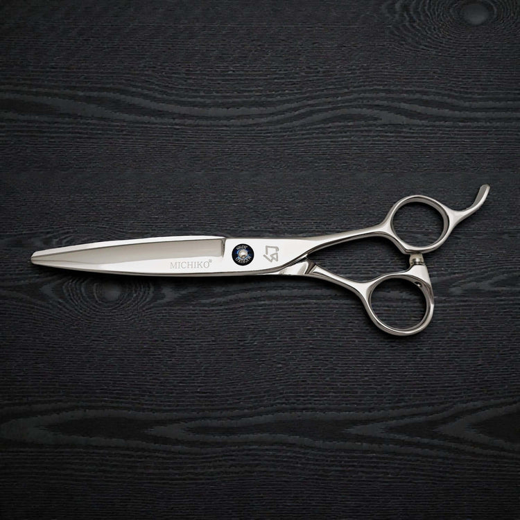 Hair cutting shears on a dark wooden surface