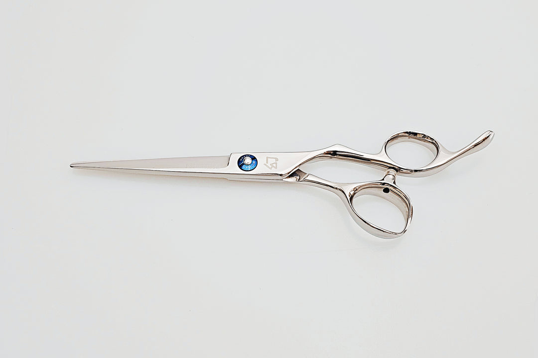 Hair scissors with a blue screw on a light gray background