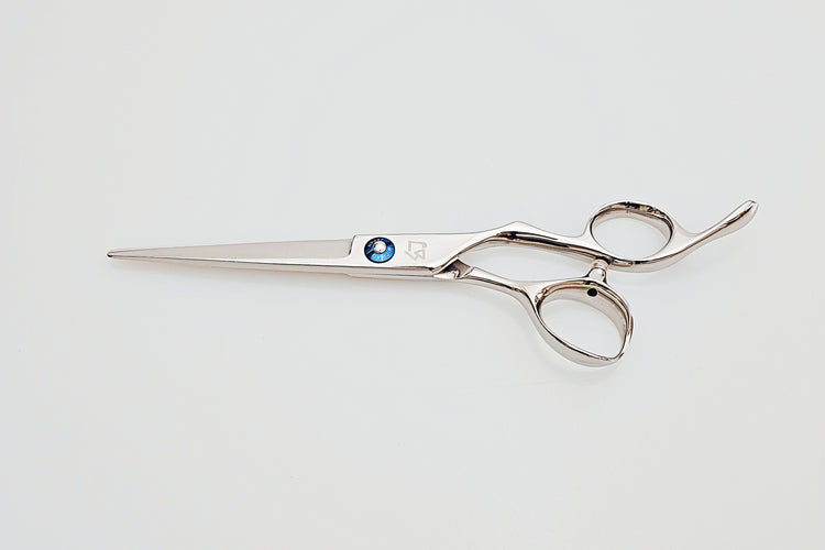 Hair scissors with a blue screw on a light gray background