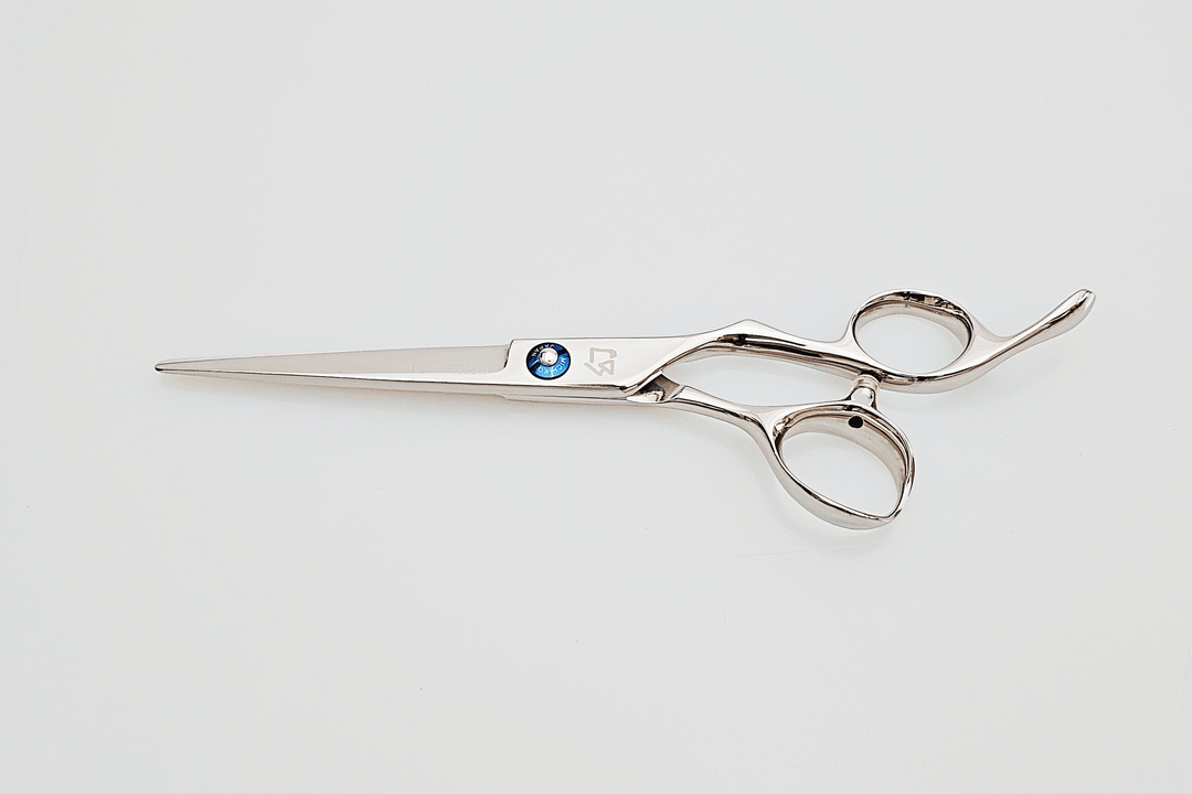 Hair scissors with a blue screw on a light gray background
