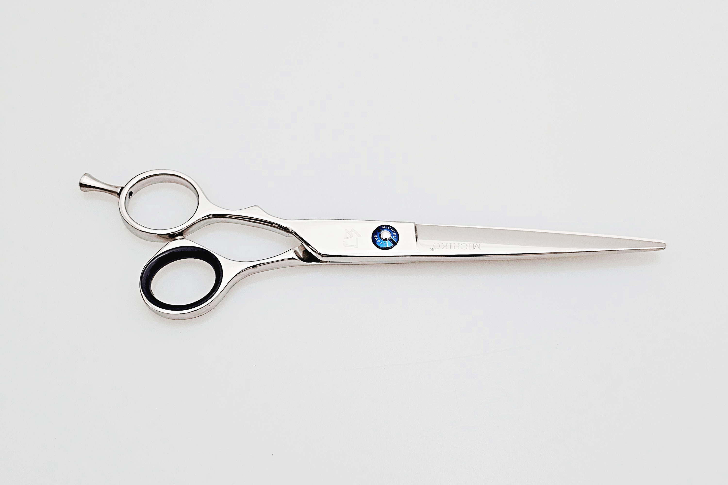 Left handed hair cutting scissors with a brand logo on a white background