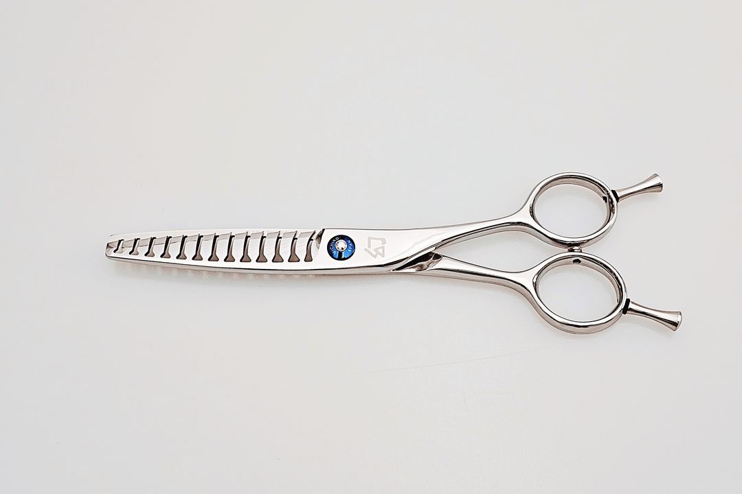 Stainless steel hair cutting shears on a light gray background