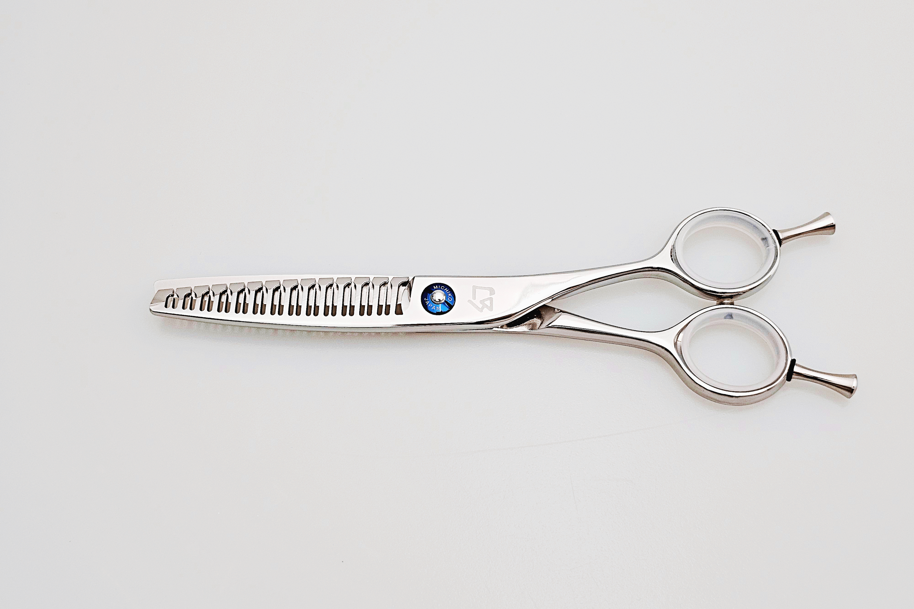 Hair scissors with a brand logo on a light gray background