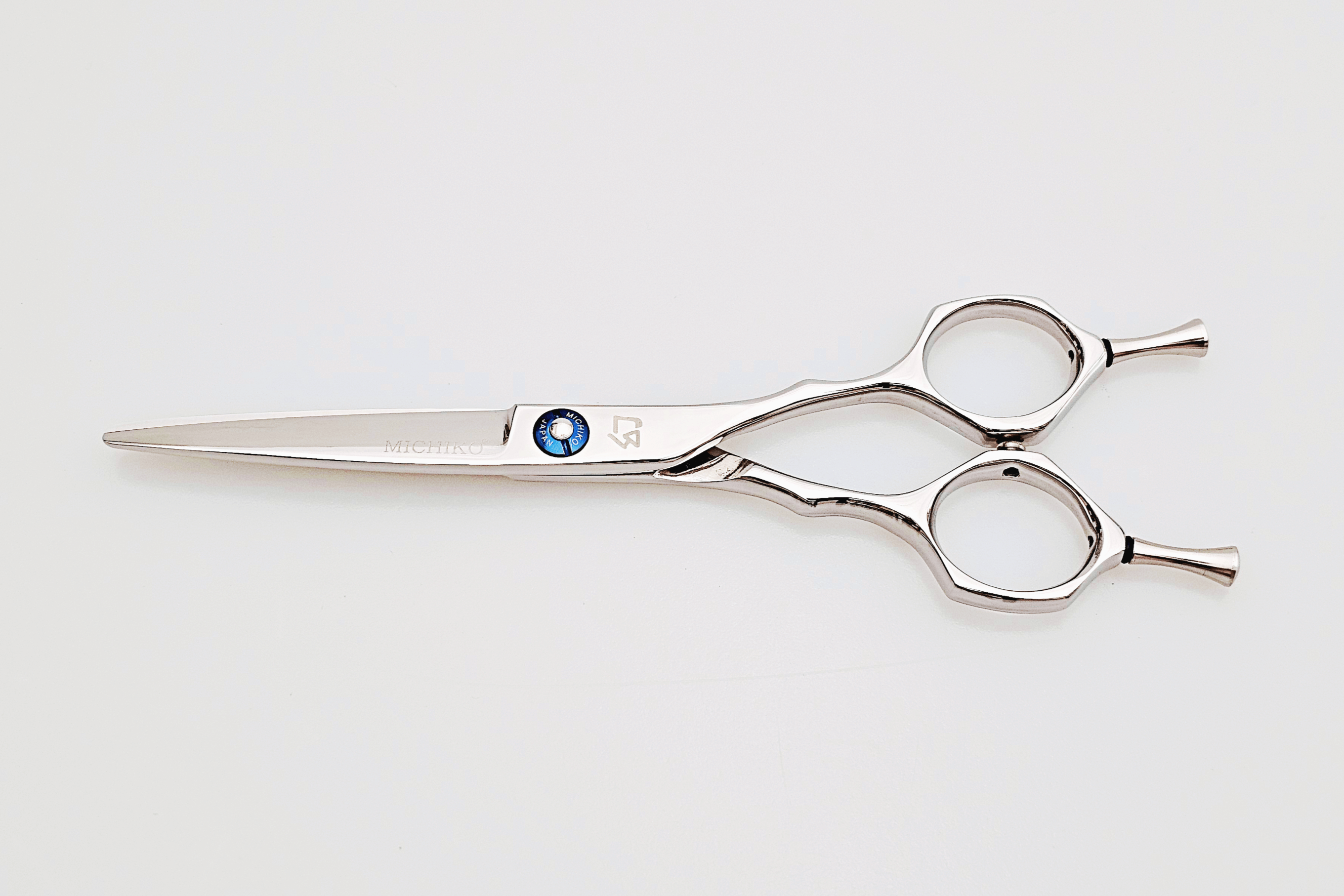 Hair scissors with a blue screw on a white background