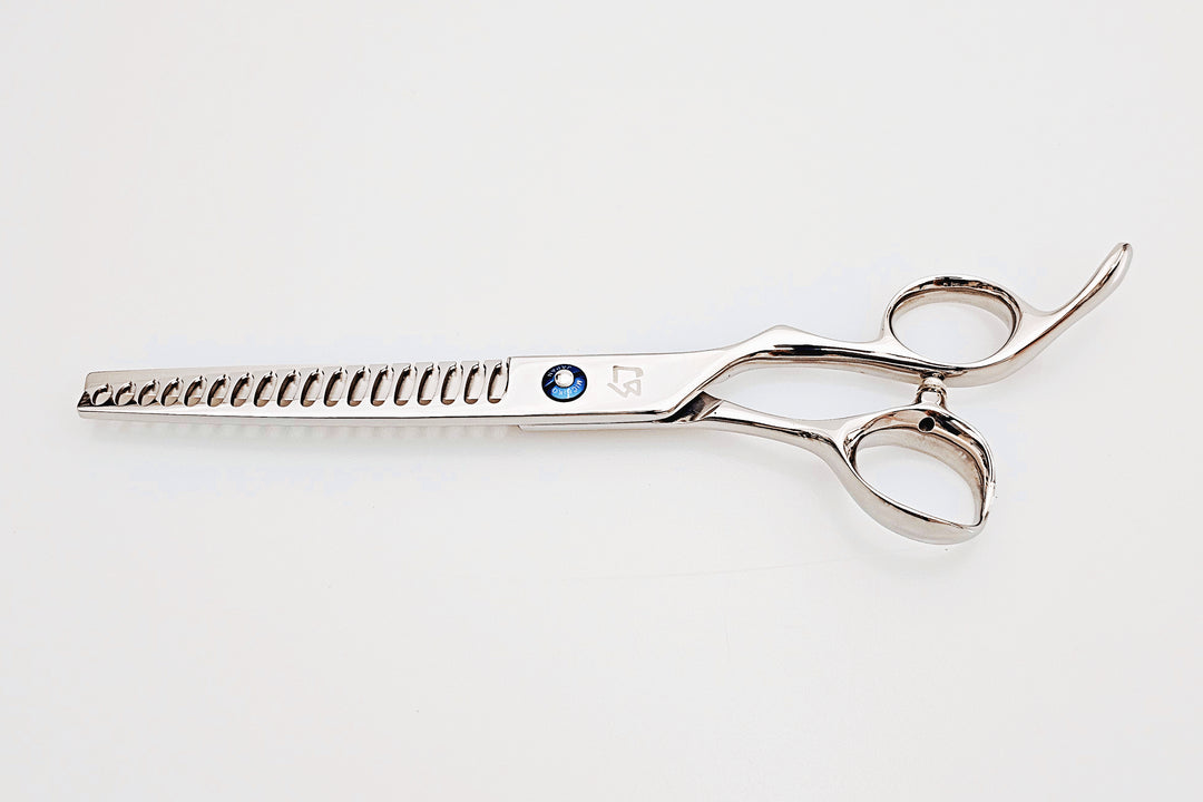 Barber texturizing shears on a white surface.